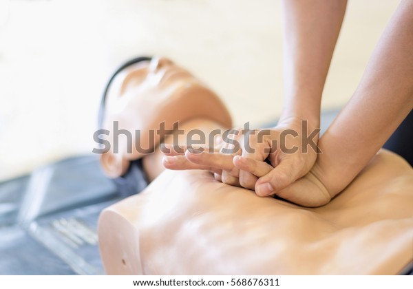 CPR training medical procedure -\
Demonstrating chest compressions on CPR doll in the class\

