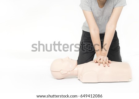 CPR training medical procedure,Demonstrating chest compressions on CPR doll in the class,White background