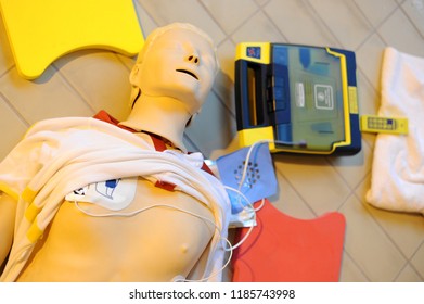 CPR training using and an AED and bag mask valve on an adult training manikin. First aid cardiopulmonary resuscitation course using automated external defibrillator device, AED.