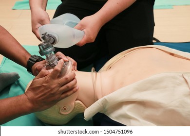 CPR training using and an AED and bag mask valve on an adult training manikin.Healthcare Concept - Powered by Shutterstock