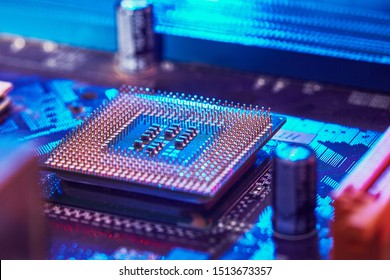 CPU desktop with the contacts facing up lying on the motherboard of the PC. the chip is highlighted with blue light. Technology background. selective focus