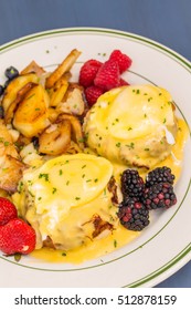 Crab Cake Eggs Benedict Served With Berries And German Potatoes