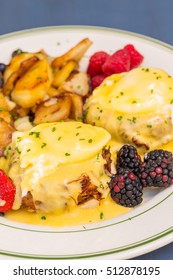 Crab Cake Eggs Benedict Served With Berries And German Potatoes