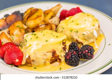 Crab Cake Eggs Benedict Served With Berries And German Potatoes