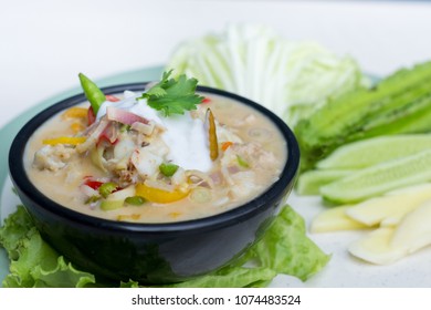 Crab dip with coconut milk and vegetables in bowl.