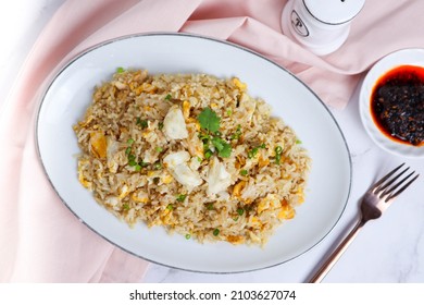 Crab Fried Rice Served With Chili Sauce And Pepper Shaker On The Side - Asian Food Served In A White Place Of Marble Table At Top View