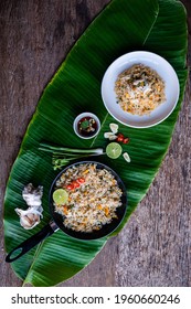 Crab Fried Rice In White Bowl And Black Pan On Banana Leaf Background, Wooden Board, Fried Rice Is Asian Food, Top View - Thai Style Concept.