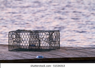 A crab pot sits on a pier in the early morning light