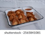 crab rangoon on a white brick background