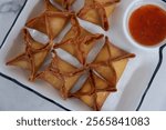 crab rangoon on a white marble background