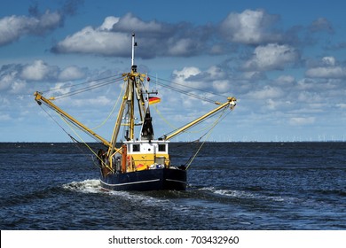 crabs or shrimp fishing boat on the North Sea under a blue sky with clouds, copy space