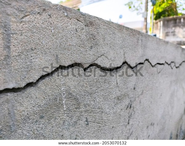 Crack cement concrete
at pavement ground from vibration for long time. Reveal big gap
from wall. Close-up.