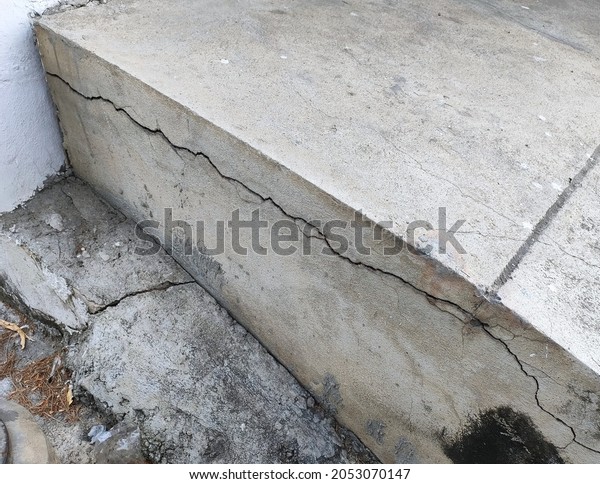 Crack cement concrete\
at pavement ground from vibration for long time. Reveal big gap\
from wall. Close-up.