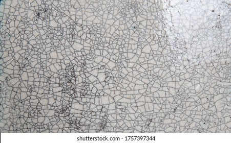 A crack pattern in the glaze of a ceramic plate.