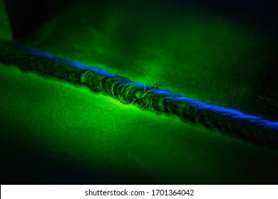 Crack steel butt weld carbon background green contrast of magnetic filed fluorescent test - Shutterstock ID 1701364042