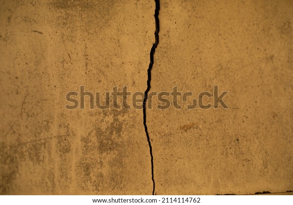 Crack in wall. Texture of concrete\
wall. Broken surface. Details of repair of\
apartment.