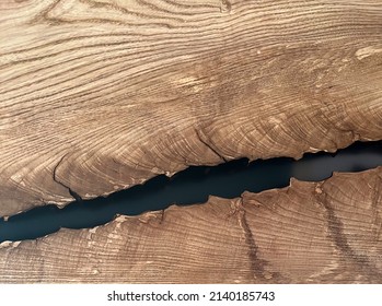 Crack in a wooden plank filled with epoxy. Close-up. Texture, pattern, background, soft focus. Space for text. High quality photo
