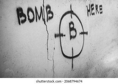 Cracked Brick Wall Background With Volume Light Rays. Fractured Concrete House Background. Painted Round Target And Bomb Here - Inscription. After Artillery Explosion