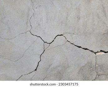 Cracked concrete wall covered with gray cement mortar. Destruction caused by an earthquake. Large uneven crack in the wall. Copy space. Texture background. Repair, construction of buildings, shrinkage - Shutterstock ID 2303457175