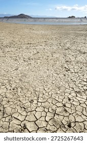 Cracked and dried mud in an empty dam, climate change image