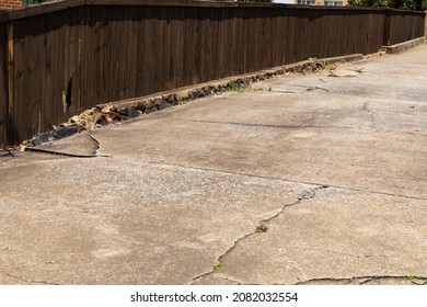 Cracked Driveway With Crumbling Curb, Dark Wood Fence Running Alongside, Creative Copy Space, Horizontal Aspect