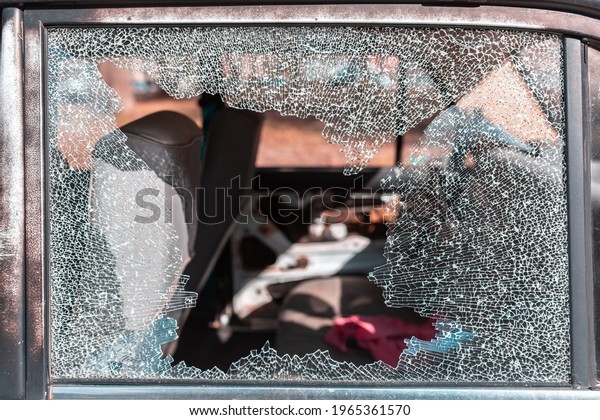 Cracked glass\
of car window with blurry\
background