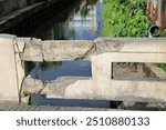 Cracked grey concrete surface with visible reinforcement, Rust in reinforcement of Concrete bridge, Broken or weak concrete.