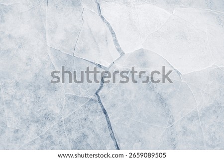 Cracked ice surface background texture with cracks in a light-blue tone.