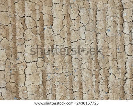 cracked land or ground texture photo, wheels print on the dry cracked gound background, outdoor design material, graphic resource