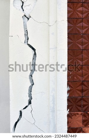 Cracked line of broken wall concrete building that was affected by the earthquake and collapsed ground