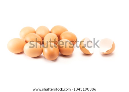 A cracked and open egg beside of other eggs isolated on white background