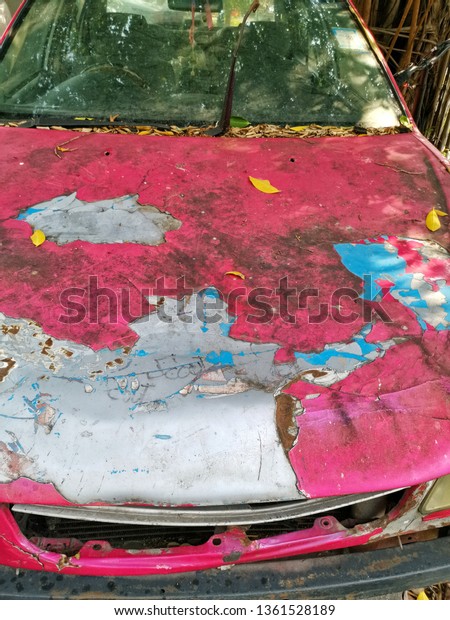 Cracked and\
peeling paint on an old bonnet car\
