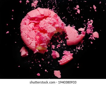 Cracked pink macaron or macaroon on the black background. Burst background, get bored, spread, irreparable, ruined, broken