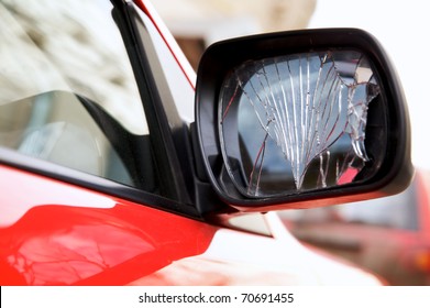 Cracked rear view mirror on a red car