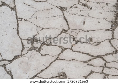 Cracked stone, flagstone texture, cracks filled with sand and pebbles, background