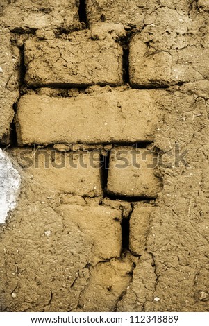 Cracked wall made up of mud-brick and soil