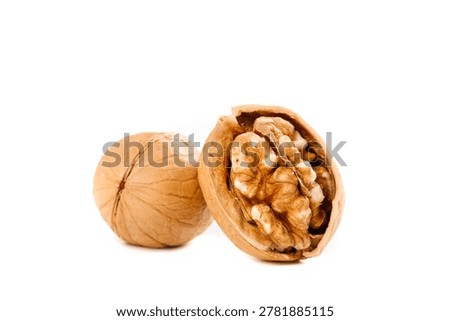 Cracked walnut showing kernels inside, isolated on white background. Nutritious nuts with peeled shell displaying edible contents.