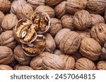 Cracked walnuts on a background covered with walnuts