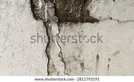 A cracked white wall with surface lines caused by age and extreme weather.