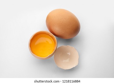 Cracked And Whole Chicken Eggs On White Background, Top View