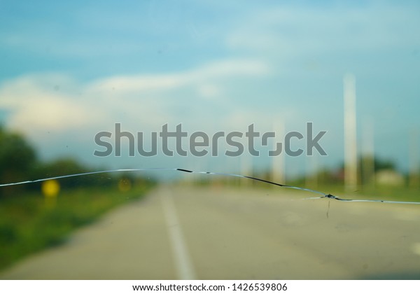 Cracked windshield or car front glass texture\
with blue sky\
background