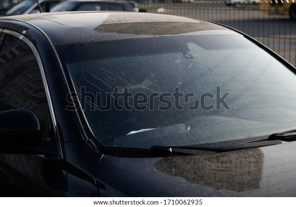 Cracked windshield. Damaged black\
car with deployed airbag. Repairs needed. Vandalism in the\
city.