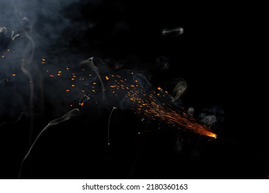 Cracker Fuse Wire Burning With Sparkles And Flame With Stunning Smoke Patterns With Red Embers Flying In The Air, Beautifully Isolate On Black Background 