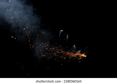 Cracker Fuse Wire Burning With Sparkles And Flame With Stunning Smoke Patterns With Red Embers Flying In The Air, Beautifully Isolate On Black Background 