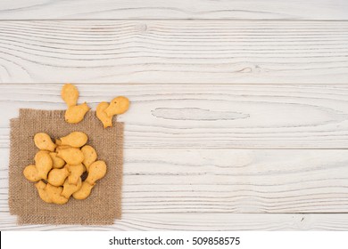 Cracker Goldfish On Sackcloth And Wooden Table. Top View.