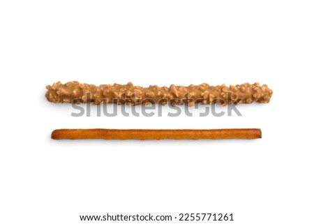 Cracker pretzel sticks toffee-cream glazing and peanuts isolated on white background. Top view.
