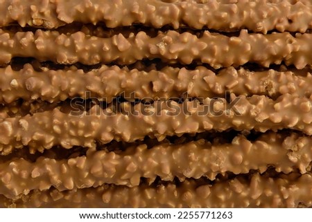 Cracker pretzel sticks toffee-cream glazing and peanuts texture or background.