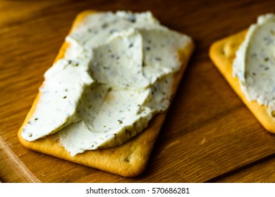 Cracker Spread With Herbal Cream Cheese. A Tasty And Easy Snack, Here On A Wooden Tray. Shallow Focus And Blurred Background.