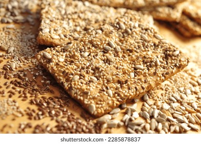 Crackers with seeds on wooden background, closeup.