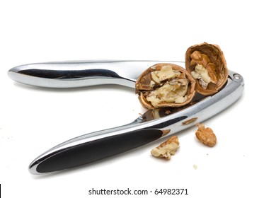 Cracking walnuts with nutcracker over white background